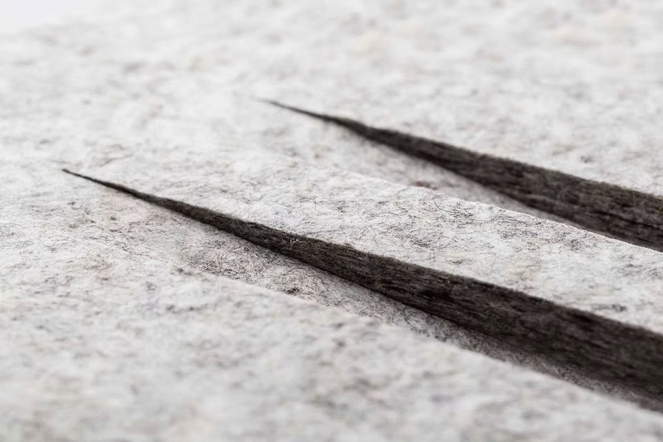 Close-up of layered grey fibre with cut grooves